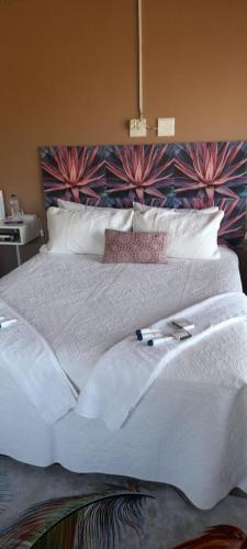 a large white bed with two books on it at S & V Accommodation in Cape Town