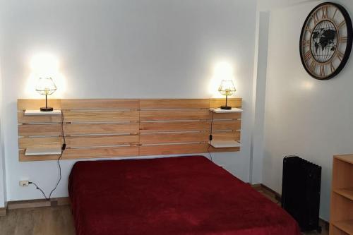 une chambre avec un lit et deux lampes au mur dans l'établissement Studio indépendant de plain-pied très calme agréé Chèques Vacances, à Drancy