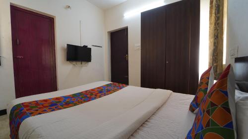 a bedroom with a bed with a colorful blanket on it at Honey Residency Airport Codissia stay in Coimbatore