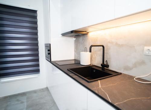 a kitchen counter with a sink and a window at Apartmani Mila in Laktaši