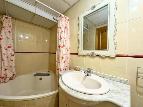 a bathroom with a sink and a tub and a mirror at Apartamentos Dos Torres Gandalf - Excelente ubicación centrica con garaje incluido in Zaragoza