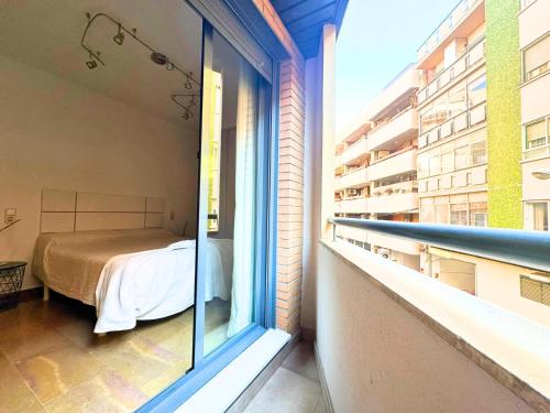 Una ventana con vistas a una habitación con cama en Apartamentos Dos Torres Gandalf - Excelente ubicación centrica con garaje incluido en Zaragoza