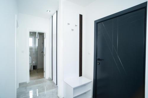 a bathroom with a black door and a mirror at Apartmani Mila in Laktaši