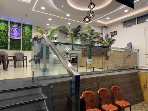 una hall con bancone, sedie e piante di Hotel Shreeji Residency a Pachmarhī