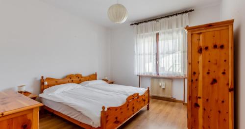 1 dormitorio con cama de madera y ventana en Lioda Sun, en Valle di Cadore