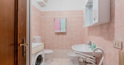 Baño rosa con lavabo y aseo en Lioda Sun, en Valle di Cadore