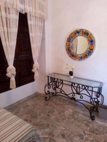 a room with a table and a mirror on the wall at Casa Rosa Amelia in Guadalajara
