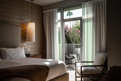 a bedroom with a bed and a chair and a window at Sanctuary Camelback Mountain Resort and Spa in Scottsdale