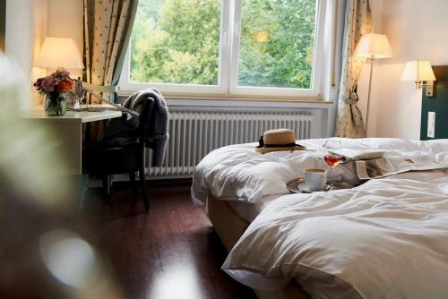 a hotel room with two beds and a desk and a window at Landgasthof Läuterhäusle in Aalen