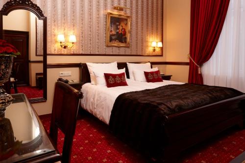 a bedroom with a large bed with red carpet at Hotel Villa Achenbach in Düsseldorf