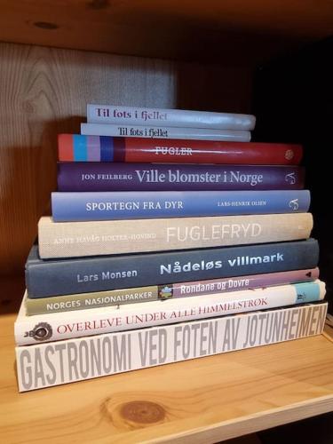 a stack of books sitting on a table at Koslig hytte ved Grimsdalen in Dovre