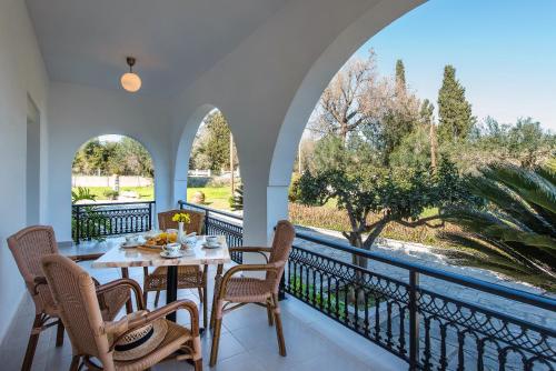 a dining room with a table and chairs on a balcony at Villa INVA Korfu in Kavos