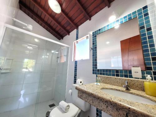 ein Badezimmer mit einem Waschbecken, einem WC und einem Spiegel in der Unterkunft Centro Up! in Búzios