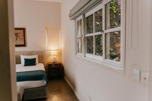 Un dormitorio con una cama y dos ventanas. en BENS L'Hôtel Palermo, en Buenos Aires