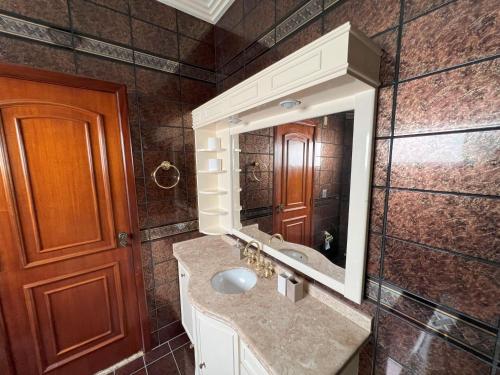 een badkamer met een wastafel en een spiegel bij Suíte no centro com 2 camas e hidromassagem in Sinop