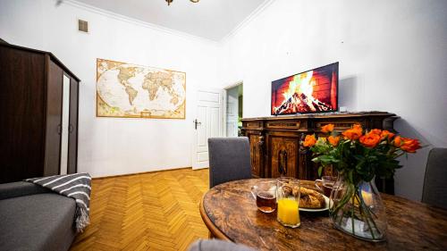 uma sala de estar com uma mesa com flores e uma televisão em Apartment with Antique furniture in The Old Town, metro em Varsóvia