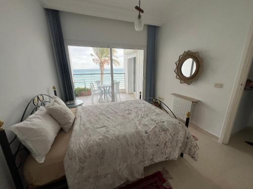a bedroom with a bed with a view of the ocean at Mahdia vue sur mer 2 in Hiboun