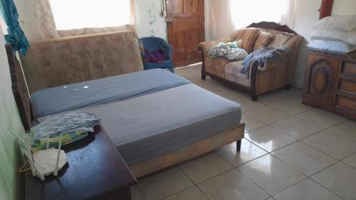 a bedroom with two beds and a couch at Fullmoon Guasacate House in Popoyo