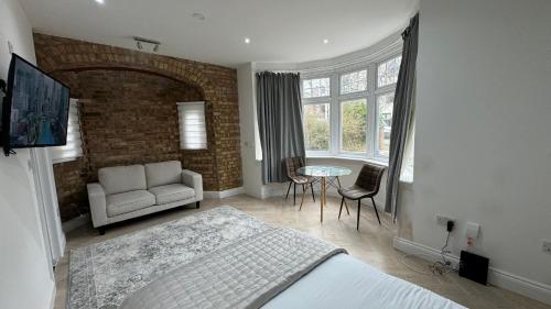 1 dormitorio con cama, sofá y mesa en London Studios and Suites, en Harrow