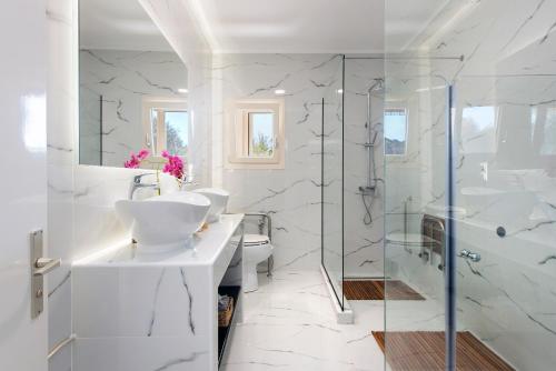 biała łazienka z umywalką i prysznicem w obiekcie Villa INVA Korfu w mieście Kavos