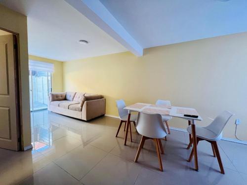 een woonkamer met een tafel en stoelen en een bank bij Casa 4 habitaciones 1 baño in Talca