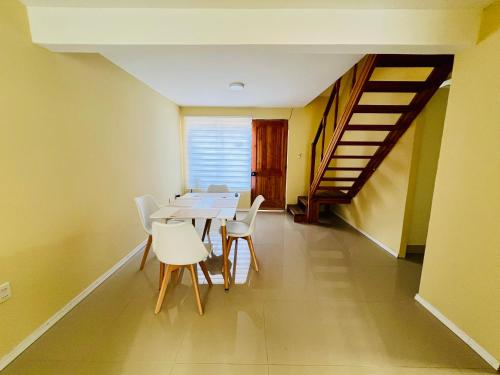a dining room with a table and white chairs at Casa con buena conectividad en Talca in Talca