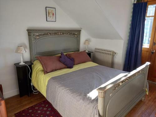 - une chambre avec un grand lit et des oreillers dans l'établissement Les Quatre Vents, à Avallon