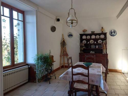 une salle à manger avec une table et une fenêtre dans l'établissement Les Quatre Vents, à Avallon