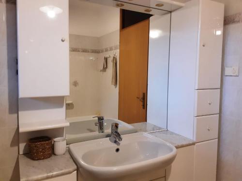 ein weißes Badezimmer mit Waschbecken und Dusche in der Unterkunft Villa Cares - Pension mit Tischtennis in Cares
