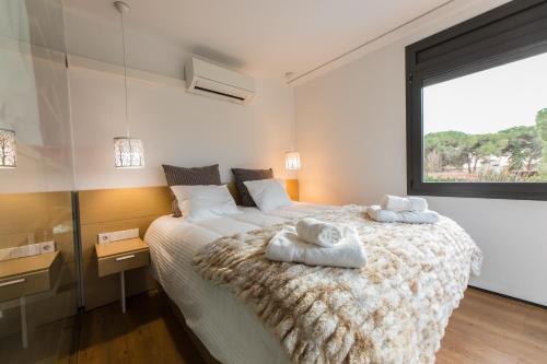 1 dormitorio con 1 cama grande y toallas. en Chalet Els pins, Banyoles, en Banyoles