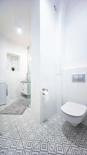 a bathroom with a toilet and a glass shower at Spacious Apartment with 3 meter ceilings, Powiśle, The Old Town in Warsaw