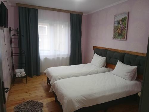 a bedroom with two beds and a window at Принцеса Анастасия 2 in Chiprovtsi