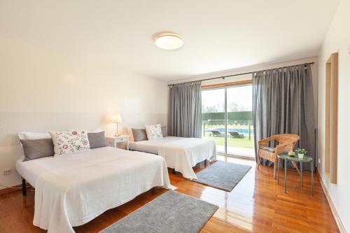 - une chambre avec 2 lits, un canapé et une fenêtre dans l'établissement Solar de Prado - Minho's Guest, à Vila de Prado