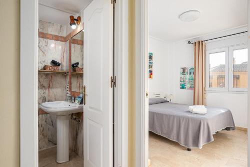 Habitación con baño con cama y lavabo. en Lantanas Studio, en Chiclana de la Frontera
