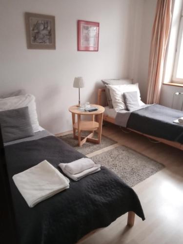 a room with two beds and a table with a table at Retro Hotel Villa Ostrava in Ostrava