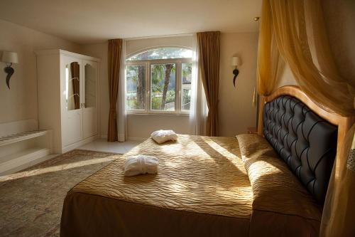 a bedroom with a large bed with two towels on it at Monastero Resort & Spa - Garda Lake Collection in Soiano del Lago