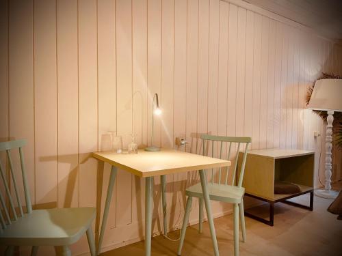 a table with two chairs and a lamp in a room at Absteige zur bärtigen Therese in Trahütten