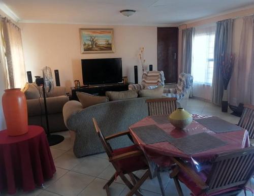 uma sala de estar com um sofá e uma mesa em JJP SELF CATERING - Three bedroom house em Lüderitz