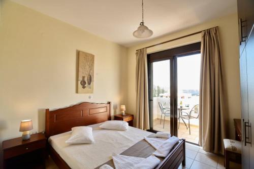 a bedroom with a large bed and a large window at Villa Gereoudis Apartments with Sea View & Pool in Kolymvari