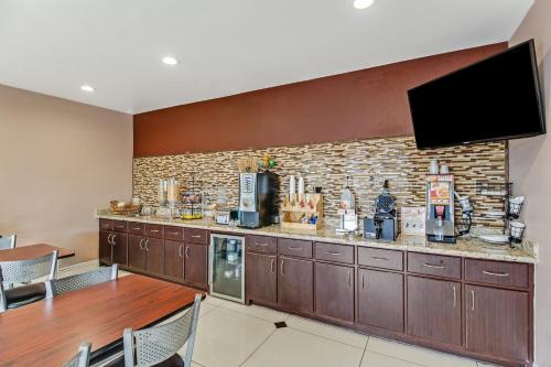 a kitchen with a bar with a tv on a brick wall at Americas Best Value Inn - FM 529 in Houston