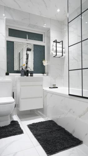 a white bathroom with a sink and a toilet at ETIHCITY - 3 Bedroom Semi - Free Parking near Etihad Stadium, Tourist attractions, Manchester City Centre, Transport and Motorway Links next to McDonald's - Sky n Netflix in Manchester