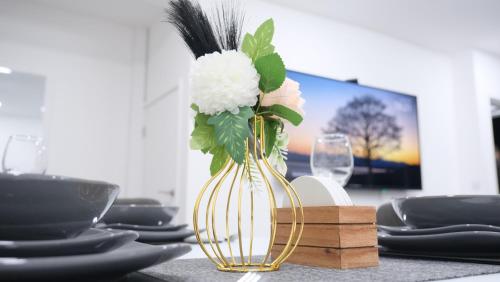 a vase with flowers in it on a table at ETIHCITY - 3 Bedroom Semi - Free Parking near Etihad Stadium, Tourist attractions, Manchester City Centre, Transport and Motorway Links next to McDonald's - Sky n Netflix in Manchester