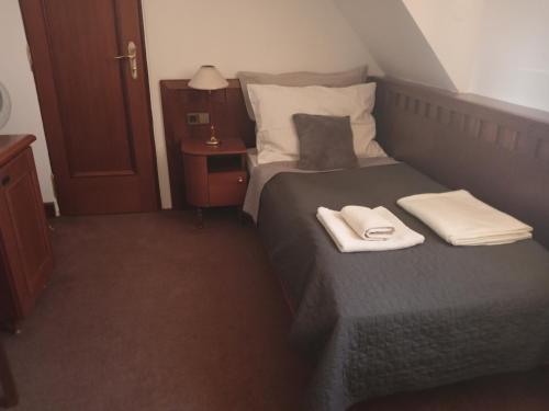 a bedroom with a bed with two towels on it at Retro Hotel Villa Ostrava in Ostrava