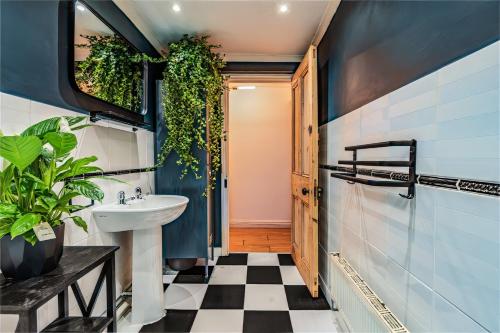 a bathroom with a black and white checkered floor at Chic Victorian Basement Flat in Bristol