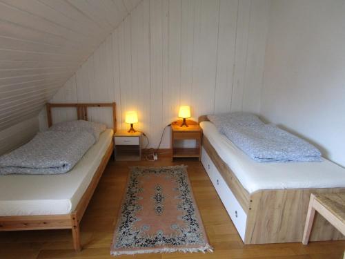 ザールブリュッケンにあるFerienwohnung Nr. 2のベッド2台、ランプ2つ(テーブル付)が備わる客室です。