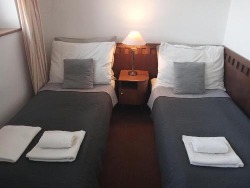 two beds in a hotel room with towels on them at Retro Hotel Villa Ostrava in Ostrava