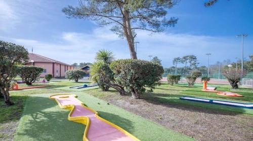 a playground with a slide in a park at Villa Soustons Plage / Résidence les villas du lac avec piscine in Soustons