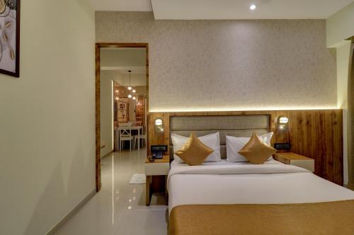 um quarto com uma grande cama branca com almofadas douradas em Home2 Studio Apartments em Mumbai