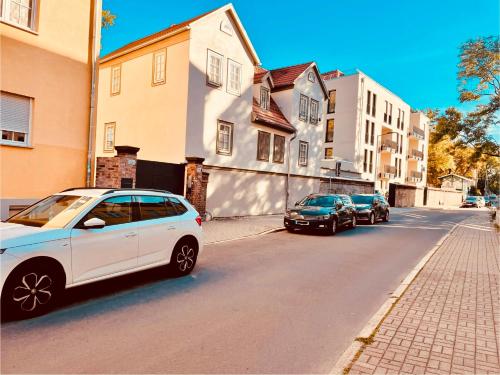 a white car parked on the side of a street at Ferienwohnungen Mey Haus zum Rosenstock in Erfurt