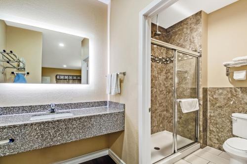 ein Bad mit einer Dusche und einem Waschbecken in der Unterkunft Americas Best Value Inn - FM 529 in Houston